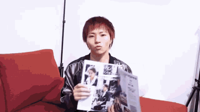 a man with red hair is holding a magazine in his hands