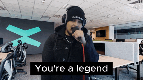 a man singing into a microphone with the words " you 're a legend " behind him