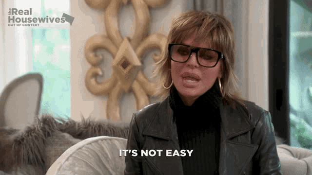 a woman wearing glasses says it 's not easy in front of a real housewives logo