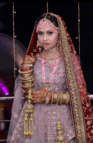 a woman in a bride 's dress is wearing many bracelets