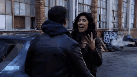 a man and a woman are standing next to each other in front of a building .