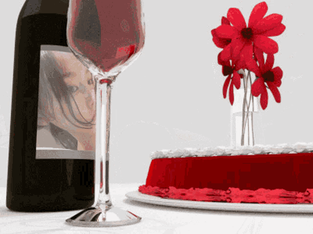 a bottle of wine next to a glass and a cake