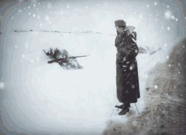 a man standing in the snow with a rifle