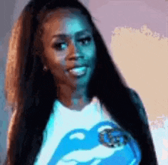a woman with long hair is wearing a rolling stones t-shirt and smiling .