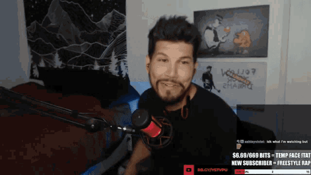 a man with a beard is sitting in front of a microphone with a sign that says $ 6.69