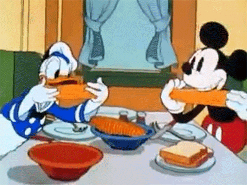 mickey mouse and donald duck are sitting at a table eating sandwiches