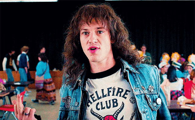 a man wearing a hellfire club t-shirt and denim jacket