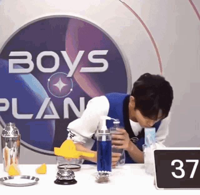 a man is drinking from a bottle in front of a sign that says 37