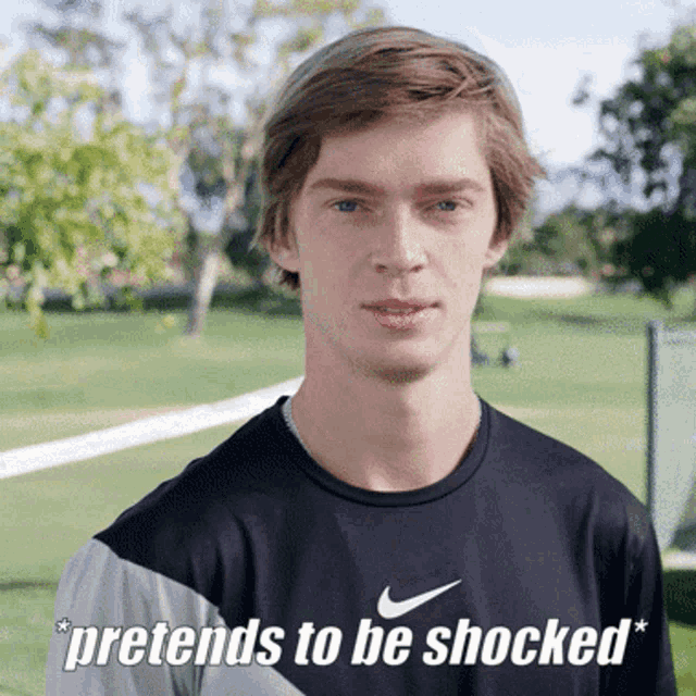 a man wearing a black nike shirt says " pretends to be shocked "