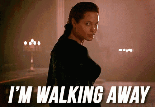a woman is standing in a dark room with the words " i 'm walking away " on the bottom
