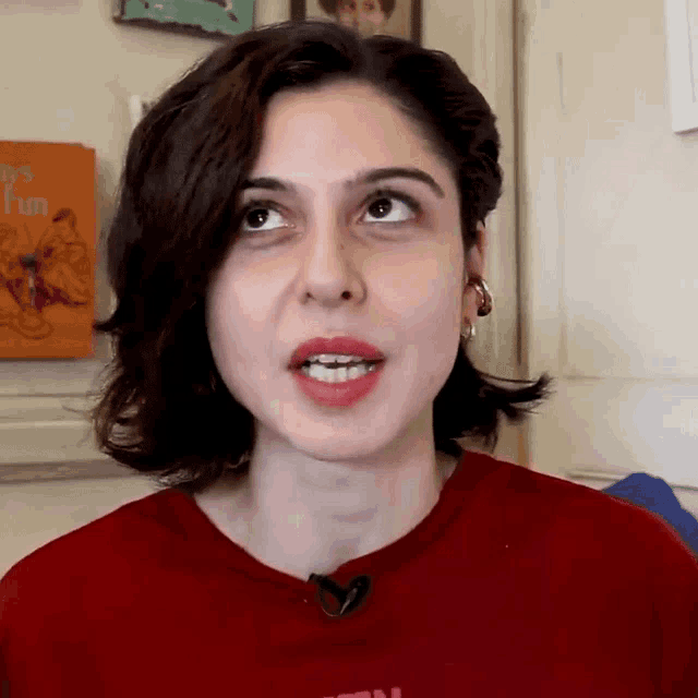 a woman wearing a red shirt with the word fun on it looks up