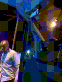 a man in a white shirt is standing in front of a truck that says triumph on the side