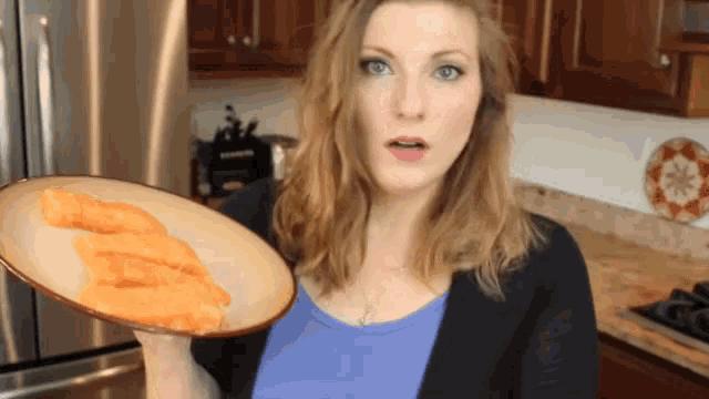 a woman is holding a plate with a piece of fish on it
