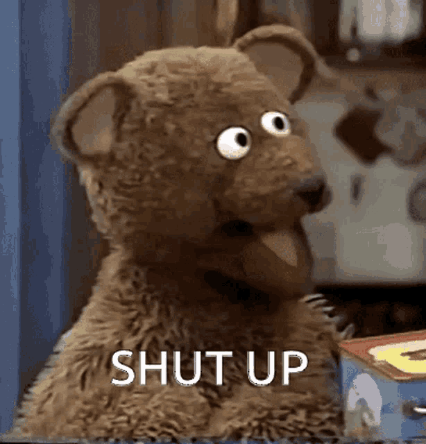 a close up of a stuffed animal with the word shut up written on it