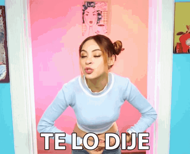 a woman in a blue sweater is making a funny face and says te lo dije