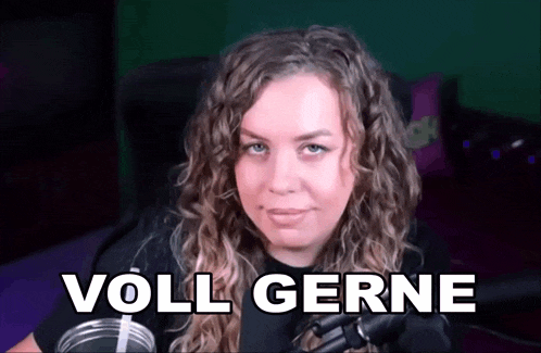 a woman with curly hair is sitting in front of a microphone and the words voll gerne are on the screen behind her