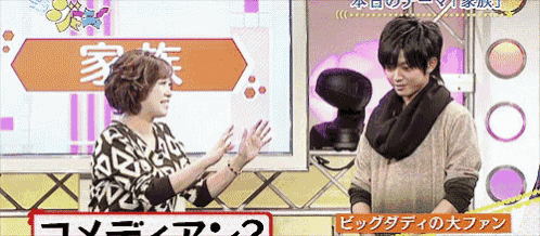 a man and a woman are standing next to each other in front of a sign that says ' comedy 2 '