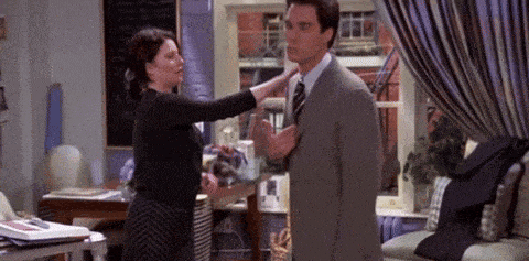 a woman is adjusting a man 's tie in a room .