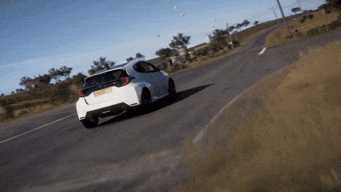 a white car is driving down a road with a yellow license plate that says ' gp ' on it