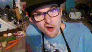 a man wearing glasses and an apron is standing in a kitchen