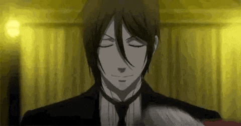a man in a suit and tie is standing in front of a yellow curtain with his eyes closed .