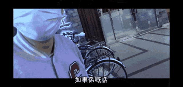 a man wearing a mask stands in front of a row of bikes