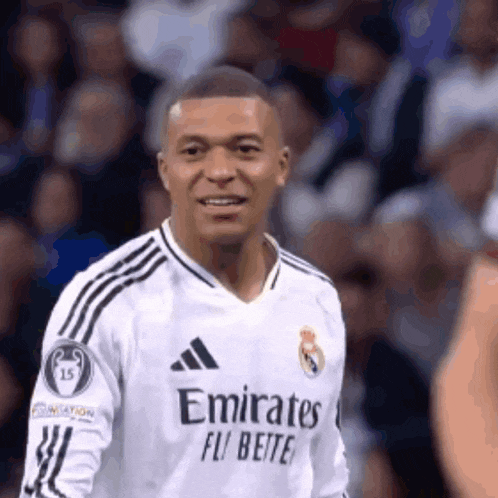 a soccer player wearing a white jersey with emirates fly better on it