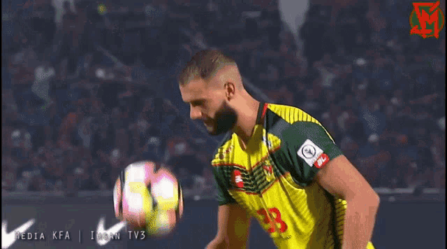 a soccer player wearing a yellow and green jersey with the number 19 on it