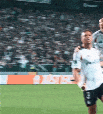 a blurry picture of a soccer game with a sign in the background that says oasis