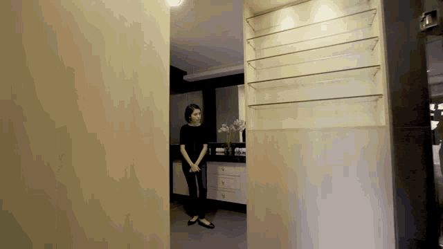 a woman is standing in a room behind a sliding glass door