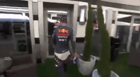 a man in a red bull shirt is walking in a building .