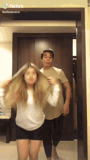 a man and a woman are dancing in a room and the woman is wearing a mask on her face .