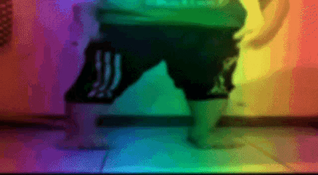 a blurry image of a person 's legs with a rainbow background