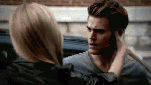 a woman is touching a man 's face in a car