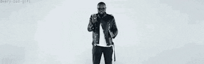 a man in a leather jacket is covering his face with his hands and looking at the camera .