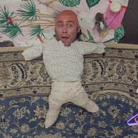 a doll with a bald head is laying on a bed