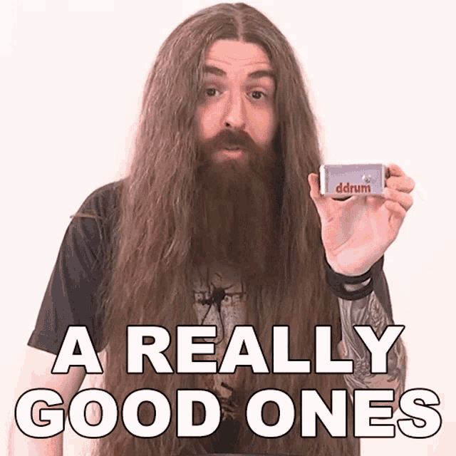 a man with long hair and a beard is holding a ddrum device
