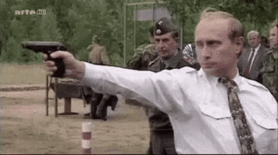 a man in a white shirt and tie is pointing a gun at someone .