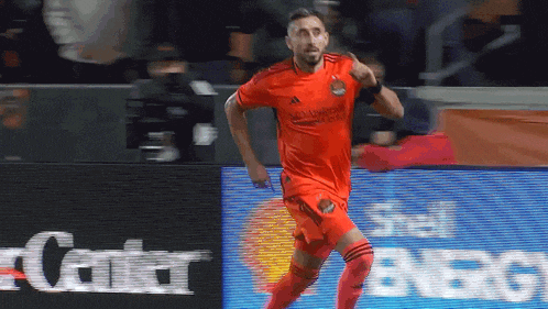 a soccer player in a red adidas jersey is running