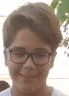a young boy wearing glasses and a white shirt is smiling for the camera .