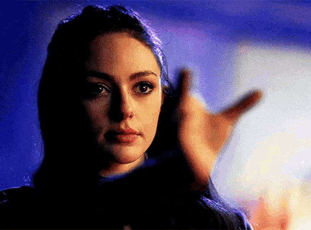 a close up of a woman 's face with a hand reaching out .