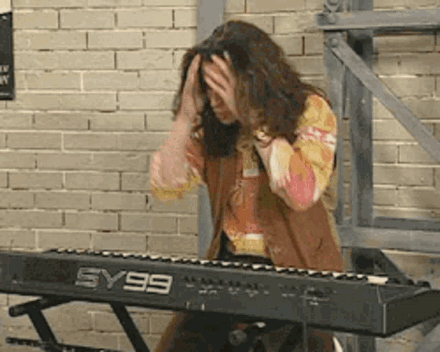 a woman is playing a keyboard with sy99 on it