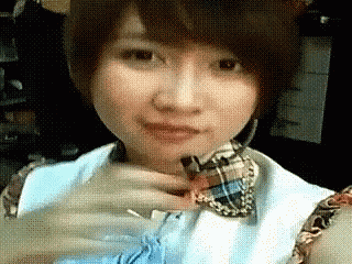 a close up of a woman 's face with a watch on her wrist .