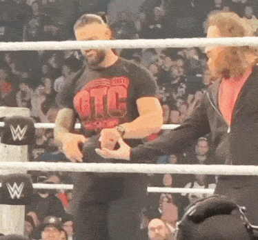 two men in a wrestling ring with one wearing a shirt that says otc