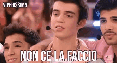 a man with a microphone on his neck is surrounded by other men and says non ce la faccio .