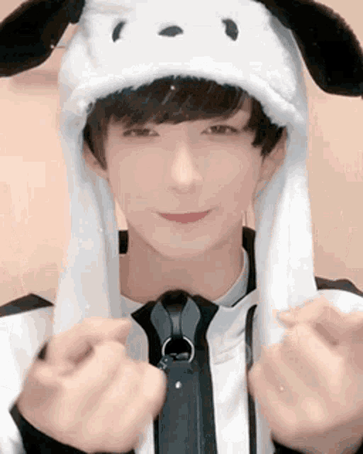 a young man wearing a white hat with bunny ears and a tie .