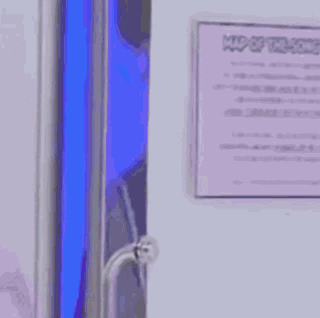 a man is peeking out of a doorway .
