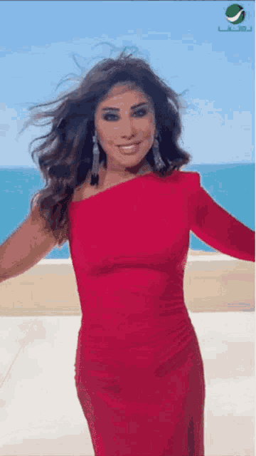 a woman in a red dress is smiling and dancing