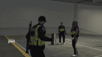 a police officer standing next to a man laying on the ground in a parking lot