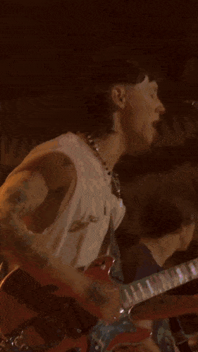 a man wearing a harley davidson shirt singing into a microphone